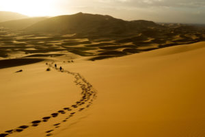 Desert landscape with a path of footprints in the sand