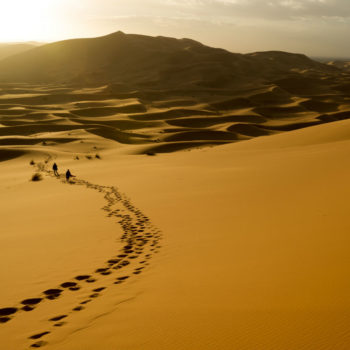 Desert landscape with a path of footprints in the sand