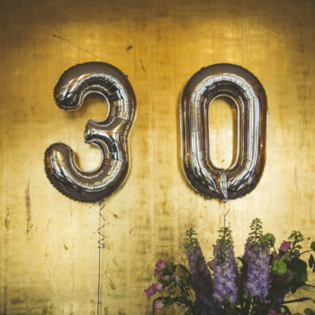 Flowers and balloons in the shape of "30"