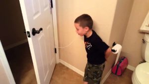 Child with his tooth tied to the handle of an open door