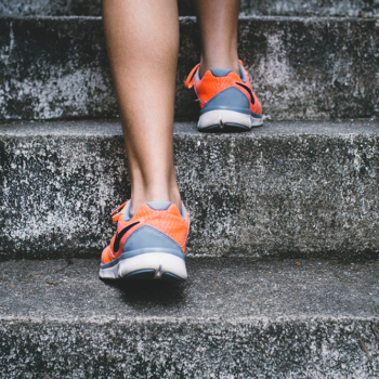 Legs in athletic sneakers ascending stairs