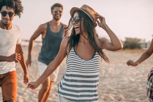 Friends smiling and running on a beach