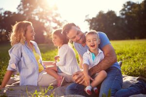 Family smiling on a picnic blanket