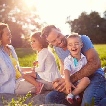 Family smiling on a picnic blanket