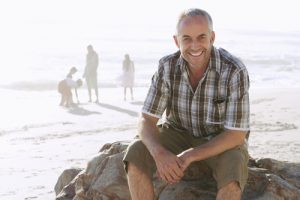 middle aged man smiling on the beach